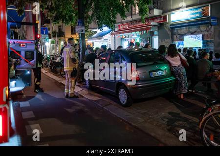 Auch Feuerwehrmänner halten nach einem Einsatz vor einem Späti in der Danziger Straße in Berlin-Prenzlauer Berg und verfolgen die letzten Minuten des Fußballspiels Deutschland gegen Schweiz anlässlich des Fußballeuropameisterschaft UEFA EURO 2024. / I vigili del fuoco si fermano anche di fronte a un Späti sul Danziger Straße a Berlino-Prenzlauer Berg dopo un'operazione e guardano gli ultimi minuti della partita di calcio Germania contro Svizzera durante il Campionato europeo di calcio UEFA EURO 2024. Istantanea-fotografia/R.. Prezzo *** i vigili del fuoco si fermano anche di fronte a un Späti a Danziger Straße a Berlin Prenz Foto Stock