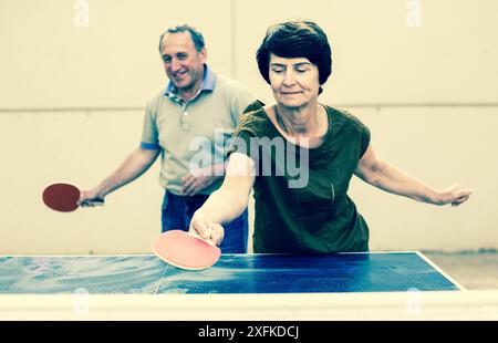 Felice matura spousesn giocare a ping pong Foto Stock