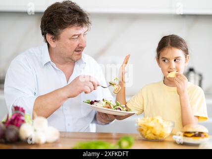 La figlia si rifiuta di mangiare cibo preparato dal padre Foto Stock