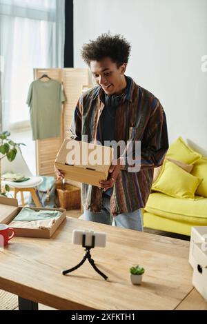 Un uomo che apre una scatola in un salotto accogliente. Foto Stock