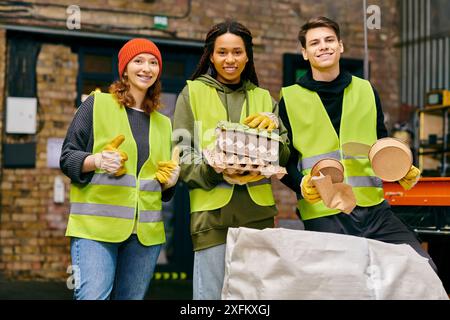 Giovani volontari in giubbotti di sicurezza e guanti per lo smistamento dei rifiuti insieme Foto Stock