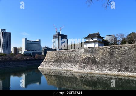 I grandi bastioni murali in pietra e gli ampi fossati che circondano i terreni del Castello di Osaka Foto Stock