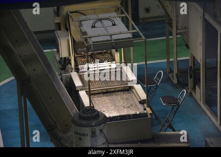 Macchine industriali della linea di produzione giapponese di monete in yen presso la sede centrale della zecca giapponese Foto Stock