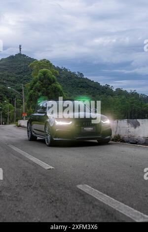 Vista frontale Audi RS6 nera, sfondo verde delle montagne, auto di lusso in giornata, alta risoluzione Foto Stock