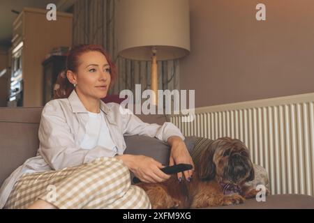 donna che si diverte e si rilassa a casa con il cane shih tzu. Concetto di tempo libero e felice a casa Foto Stock