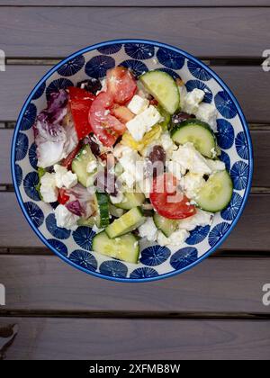 Insalata greca tradizionale con pomodori maturi, cetrioli croccanti, saporite olive nere Kalamata, formaggio feta cremoso, condito con olio d'oliva Foto Stock
