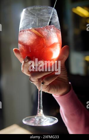 mano con bicchiere e cocktail con ghiaccio Foto Stock