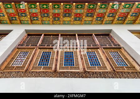 Intricate finestre in legno presso il Palazzo Shakikhanovs a Shaki, Azerbaigian, sono incorniciate da un soffitto colorato Foto Stock