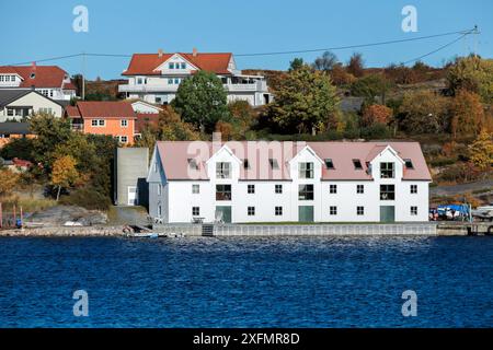 Vista del paesaggio costiero della città norvegese con fienile di legno bianco e case sullo sfondo. Kristiansund, Norvegia Foto Stock