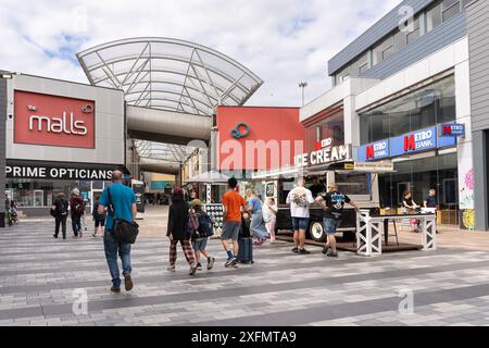 Gli amanti dello shopping e dei visitatori del "The Malls" in una giornata estiva, un centro commerciale pedonale all'aperto nel centro di Basingstoke, Hampshire, Regno Unito Foto Stock