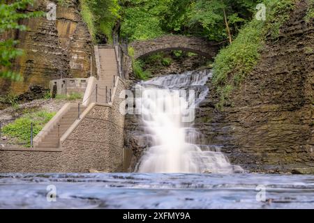 Foto di una cascata con un sentiero / scalinata in cemento, Cascadilla Gorge Trail, a Ithaca, New York, Stati Uniti. Foto Stock