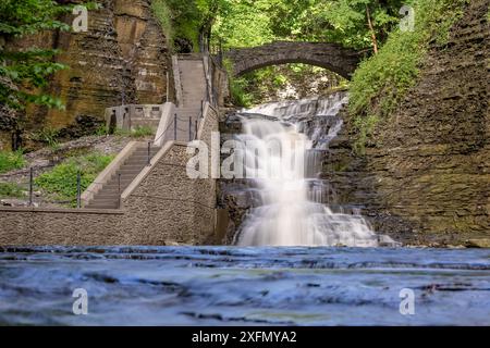 Foto di una cascata con un sentiero / scalinata in cemento, Cascadilla Gorge Trail, a Ithaca, New York, Stati Uniti. Foto Stock