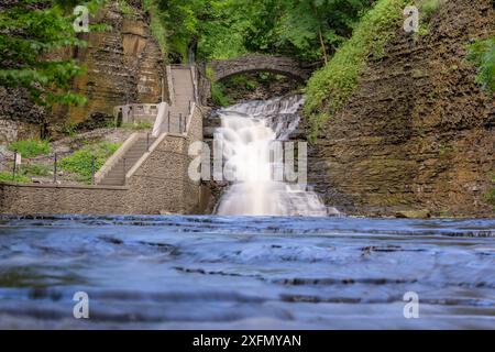 Foto di una cascata con un sentiero / scalinata in cemento, Cascadilla Gorge Trail, a Ithaca, New York, Stati Uniti. Foto Stock