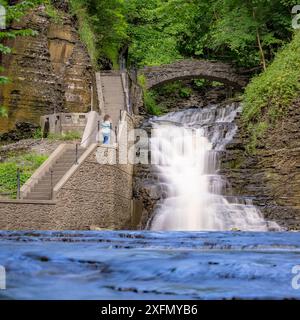 Foto di una cascata con un sentiero / scalinata in cemento, Cascadilla Gorge Trail, a Ithaca, New York, Stati Uniti. Foto Stock