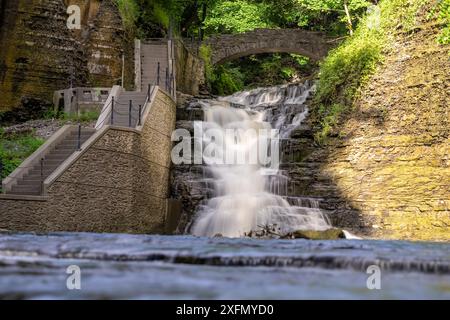Foto di una cascata con un sentiero / scalinata in cemento, Cascadilla Gorge Trail, a Ithaca, New York, Stati Uniti. Foto Stock