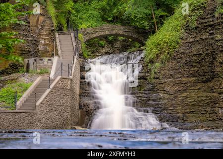 Foto di una cascata con un sentiero / scalinata in cemento, Cascadilla Gorge Trail, a Ithaca, New York, Stati Uniti. Foto Stock