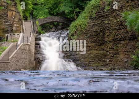Foto di una cascata con un sentiero / scalinata in cemento, Cascadilla Gorge Trail, a Ithaca, New York, Stati Uniti. Foto Stock