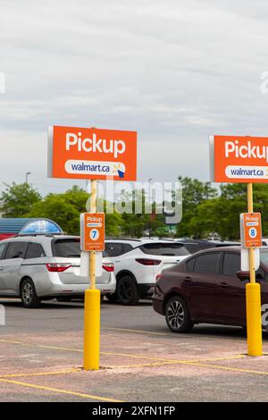 Kanata, Canada - 2 giugno 2024: Cartelli per il ritiro di Walmart. Parcheggio per gli ordini di alimentari online al supermercato. Foto Stock