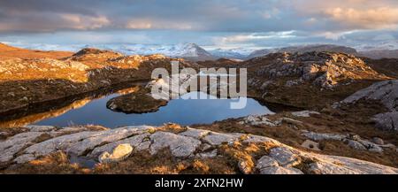 Lochan collinare remoto con vista verso Loch Torridon e Ben Damph, alla luce del tardo inverno, Wester Ross, Scozia, Regno Unito, marzo 2017 Foto Stock