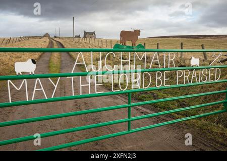 Messaggio religioso sul cancello della fattoria con croft in background, Aberdeenshire, Scozia, Regno Unito, gennaio 2017 Foto Stock