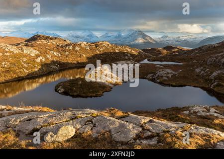 Lochan collinare remoto con vista verso Loch Torridon e Ben Damph, Wester Ross, Scozia, Regno Unito, marzo 2017 Foto Stock