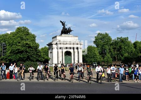 Ciclisti pendolari in attesa che le luci cambino, Hyde Park Corner, Wellington Arch in background, Central London, Inghilterra, Regno Unito, giugno 2015. Foto Stock