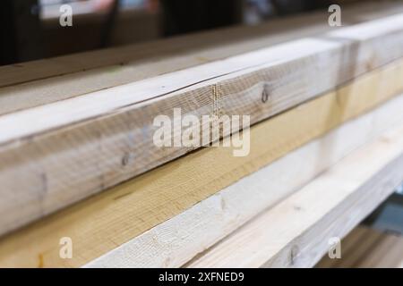 Pila di bastoni di legno a sezione quadrata lunga, leggermente piegata. Primo piano con messa a fuoco selettiva. Foto Stock