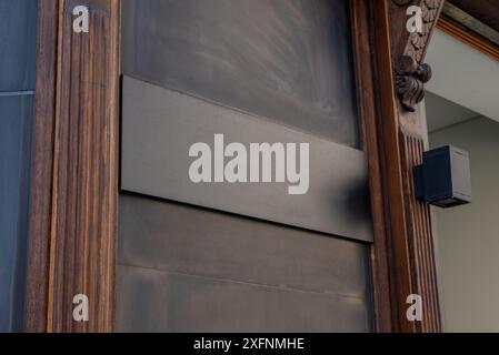 Lavagna nera su superficie in legno all'ingresso della boutique o del ristorante per la promozione del logo. Perfetto per mostrare l'identità del marchio e l'opportunità pubblicitaria Foto Stock