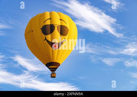 Pallone giallo ad aria calda con un volto con un grande sorriso contro un cielo estivo blu. Concetto - felice, felice, allegro, sorridente; Messico Foto Stock