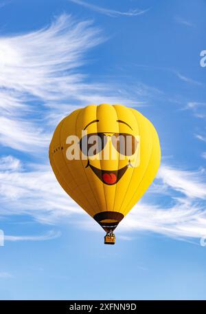 Pallone giallo ad aria calda con un volto con un grande sorriso contro un cielo estivo blu. Concetto - felice, felice, allegro, sorridente; Messico Foto Stock