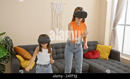 Madre e figlia giocano con i visori per la realtà virtuale in un accogliente soggiorno, godendo di un moderno intrattenimento per tutta la famiglia. Foto Stock