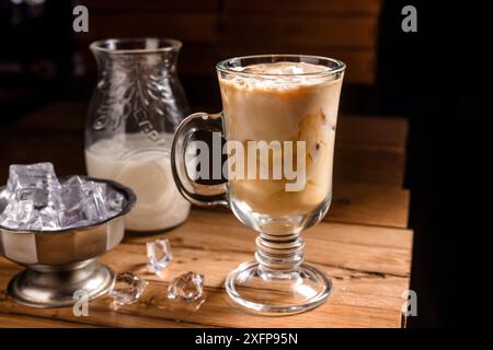 bevanda al caffè con gelato e ghiaccio su sfondo di legno scuro, bevanda tonica fredda Foto Stock