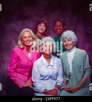 Ritratto in studio di cinque donne sorridenti di età diverse si sono pose insieme su uno sfondo viziato, mostrando amicizia, famiglia e div generazionale Foto Stock
