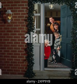 natale in famiglia. Accoglienza di ospiti, familiari, amici, scambio di regali intorno ad alberi decorati, Foto Stock