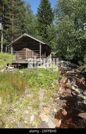 Capanna in legno con rigoglioso ruscello, Svezia centrale, Svezia, Scandinavia Foto Stock