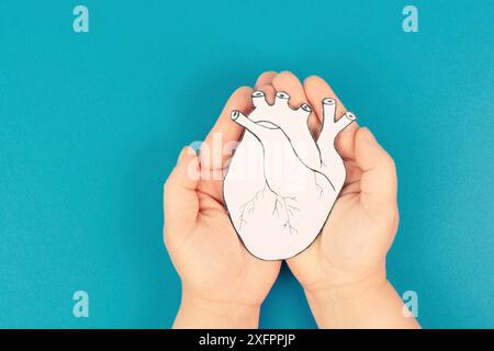 Infarto, malattia della miocardite, infiammazione del muscolo, trombosi e stress cardiaco, mani che tengono l'organo umano Foto Stock