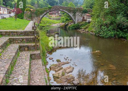 Il ponte romano sul fiume meira a Lierganes, Cantabria, Soain settentrionale con la staue di bronzo del pescatore di Lierganes presso il ponte Foto Stock