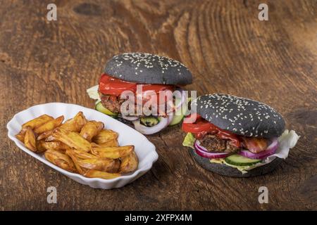 Primo piano degli hamburger neri su legno Foto Stock