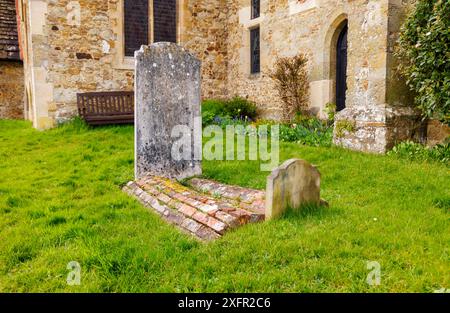 Rare tombe a botte di mattoni nel cimitero della chiesa di St Mary a Chiddingfold, un villaggio nel Surrey, nel sud-est dell'Inghilterra Foto Stock