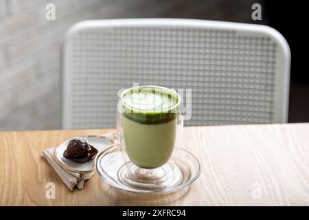 Latte matcha caldo caldo caldo e rilassante: Una ricca miscela di tè verde matcha di prima qualità e latte montato a vapore, che offre una consistenza cremosa e un sapore terroso. Foto Stock