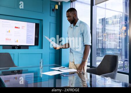 Presentazione di un rapporto finanziario, uomo d'affari in piedi in un ufficio moderno con documenti Foto Stock