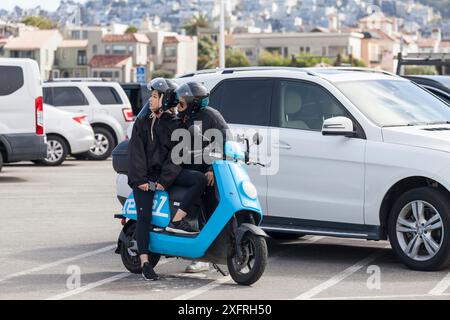 Giovane coppia asiatica su uno scooter che si diverte Foto Stock