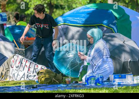 NEW ORLEANS, LOUISIANA, Stati Uniti d'America - 30 APRILE 2024: Donna in abito tradizionale palestinese e uomo che si adatta all'accampamento pro Palestina Foto Stock