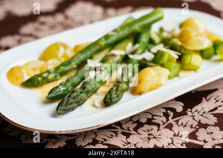 Asparagi verdi con uve saltate e salsa di vino bianco Foto Stock