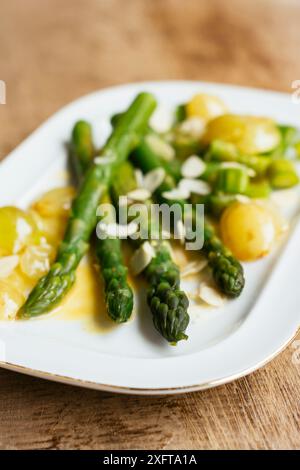 Asparagi verdi con uve saltate e salsa di vino bianco Foto Stock