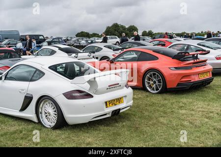 Tarporley, Cheshire, Inghilterra, 29 giugno 2024. Una Porsche Cayman bianca e una Porsche 911 GT3 arancione sono esposte a un incontro auto. Foto Stock