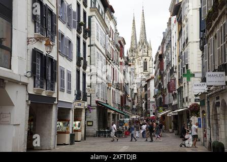 Zona commerciale, Rue de la Monnaie e cattedrale sullo sfondo, Bayonne. Paesi baschi francesi, Aquitania, Pirenei-Atlantiques, Francia Foto Stock