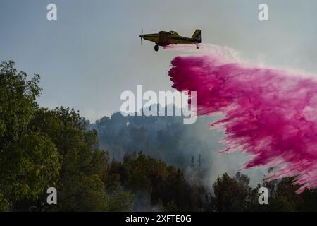 (240705) -- PECHINO, 5 luglio 2024 (Xinhua) -- Un aereo antincendio rilascia ritardanti di fiamma per estinguere gli incendi causati dai razzi lanciati dal sud del Libano, al confine settentrionale con il Libano, il 4 luglio 2024. (Ayal Margolin/JINI via Xinhua) Foto Stock