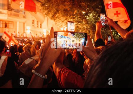 Tbilisi, Georgia - 2 luglio 2024: Evento cinematografico per appassionati di calcio con cellulare sulla nazionale di calcio georgiana arrivo a casa celebrazioni di benvenuto in capita Foto Stock