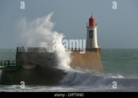 Onde che si infrangono contro il muro con la torcia elettrica, la Chaume, Les Sables d'Olonne, Vendee, Francia. Gennaio Foto Stock